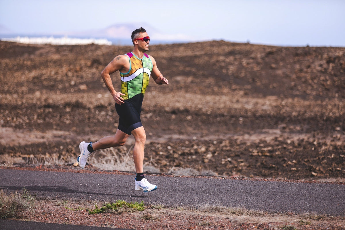  Athlete running in a tri suit during training, demonstrating efficient running form and endurance performance.